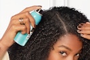 woman spraying cover up into her hair line