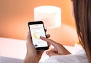 a person using her smartphone to turn on a lamp