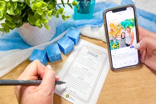 baby shower game with a person filling out and holding a phone with social media on the screen 