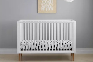 lifestyle image of a baby crib in a room