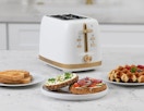 a toaster next to breakfast plates of toast and waffles