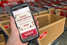 A cell phone in front of the TJ Maxx store with an annulment stating TJ Maxx will be closed on Thanksgiving.