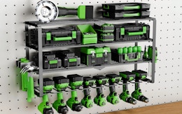 a power tool organizer on a wall with green and black tools