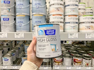 A person holding a paint can in lowes