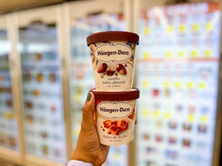 holding ice cream in front of freezer