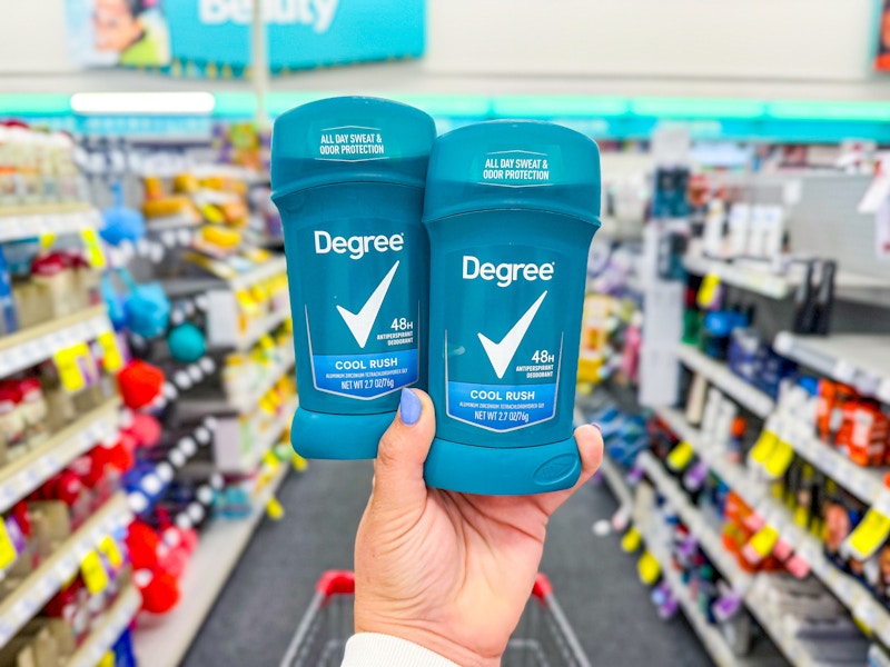 person holding 2 degree deodorants in an aisle