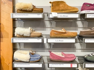 Wicked Good Slippers on a wall of display moccasin slippers inside L.L.Bean