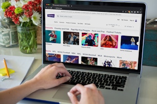 A person using a laptop to look at the StubHub website
