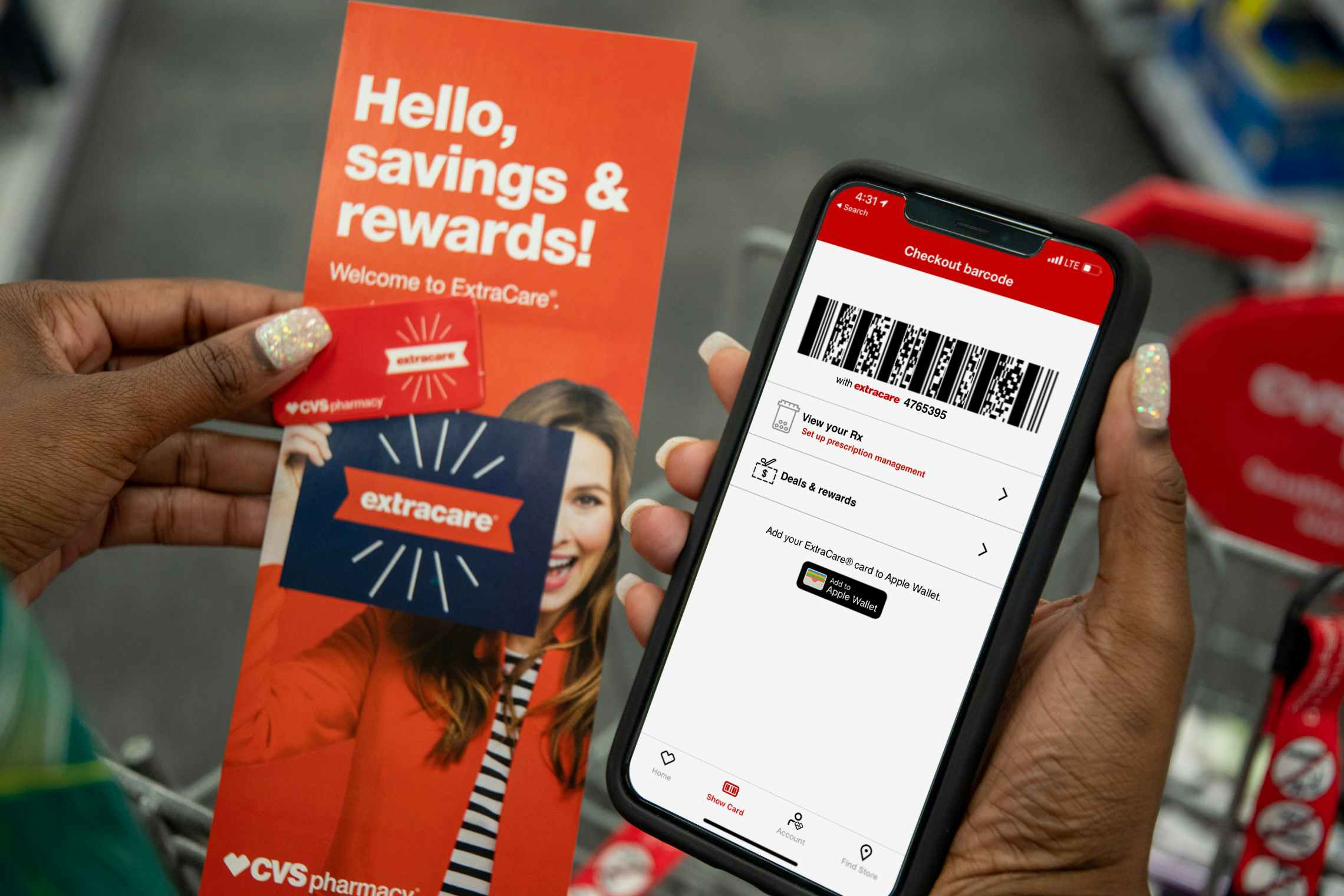 A woman holding an iPhone displaying her ExtraCare barcode on the CVS app, a rewards key chain card, and an extracare rewards pamphlet in...