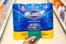 a hand holding a pack of disinfecting wipes