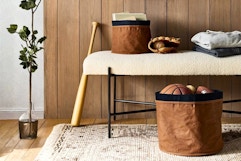 Lifestyle image of Studio McGee Canvas Storage Baskets in home setting used to store sports equipment