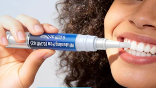 a person using a whitening pen on their teeth 