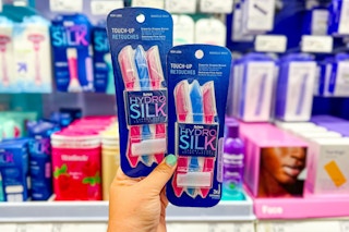 hand holding 2 packs of schick hydro silk razors in front of target shelf