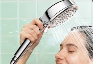 a person holding a handheld shower head