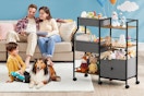 Parents sit on a beige couch with a book, a boy sits with a dog on the rug, a 3-tier organizer cart is off to the side.