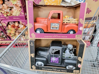 fall and halloween themed decorative pre-lit trucks in a cart