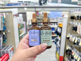 hand holding sheamoisture hair oil in walgreens