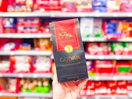 hand holding a Godive Masterpiece chocolate package