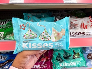 hand holding bag of kisses in front of store shelf
