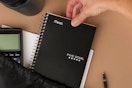 Person pulling Five Star Spiral Notebook out of bag