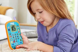 a girl playing with a vtech bluey phone toy