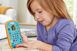a girl playing with a vtech bluey phone toy