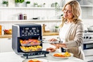Lifestyle image of woman using the Gourmia All-in-One 14-Quart Air Fryer in kitchen setting