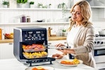 Lifestyle image of woman using the Gourmia All-in-One 14-Quart Air Fryer in kitchen setting