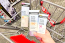 hand holding neutrogena sunscreens over a cvs shopping cart