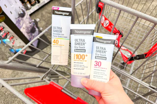 hand holding neutrogena sunscreens over a cvs shopping cart
