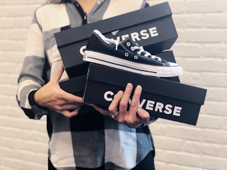 holding converse shoe boxes and sneakers