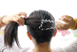 a person tie hair with a hair tie
