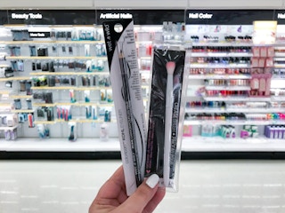 hand holding wet n wild eyeliner and a crease brush at target