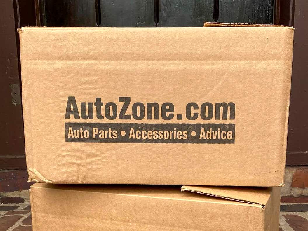 A stack of autozone.com boxes sitting on a doorstep