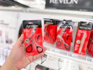 hand holding a revlon lash curler in front of target shelf