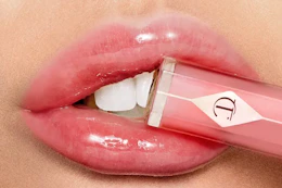a woman holding charlotte tilbury lip gloss