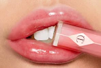 a woman holding charlotte tilbury lip gloss