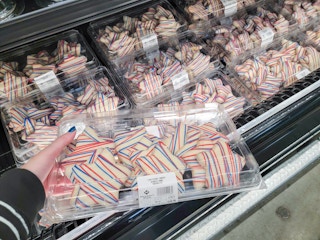hand holding a container of red, white, and blue star cookies
