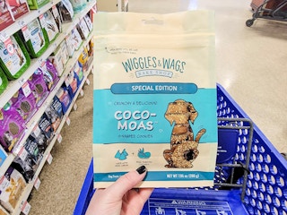 hand holding a bag of dog treats