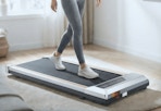 person walking on a walking pad in a sunlit living room