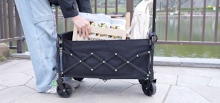 a person loading a foldable wagon