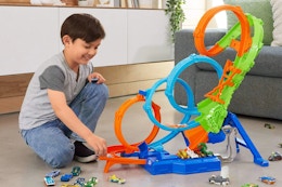 child playing with a Hot Wheels track