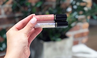 hand holding two revlon super lustrous lip glosses