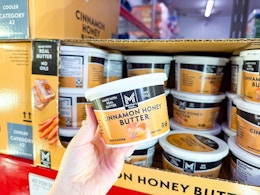 hand holding up a tub of butter at a grocery store