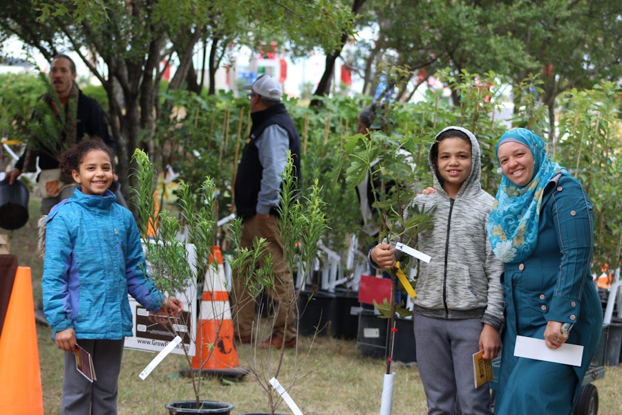 A family standing with their new trees they got for free from TreeFolks and the City of Austin, TX