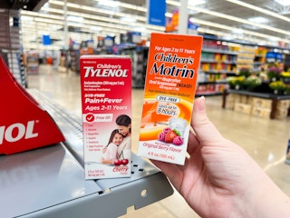 hand holding a Children's Motrin package in front of a Tylenol package