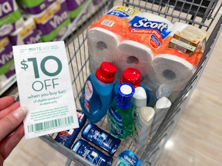 someone holding coupon next to cart full of products