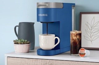 Keurig Coffee Maker on a counter top with a hot coffee being brewed and a cold coffee next to it