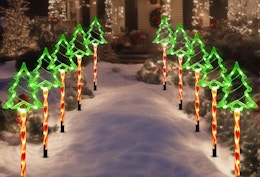 a Christmas tree lights in a walkway in front of a door