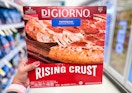 hand holding box of digiorno frozen pizza